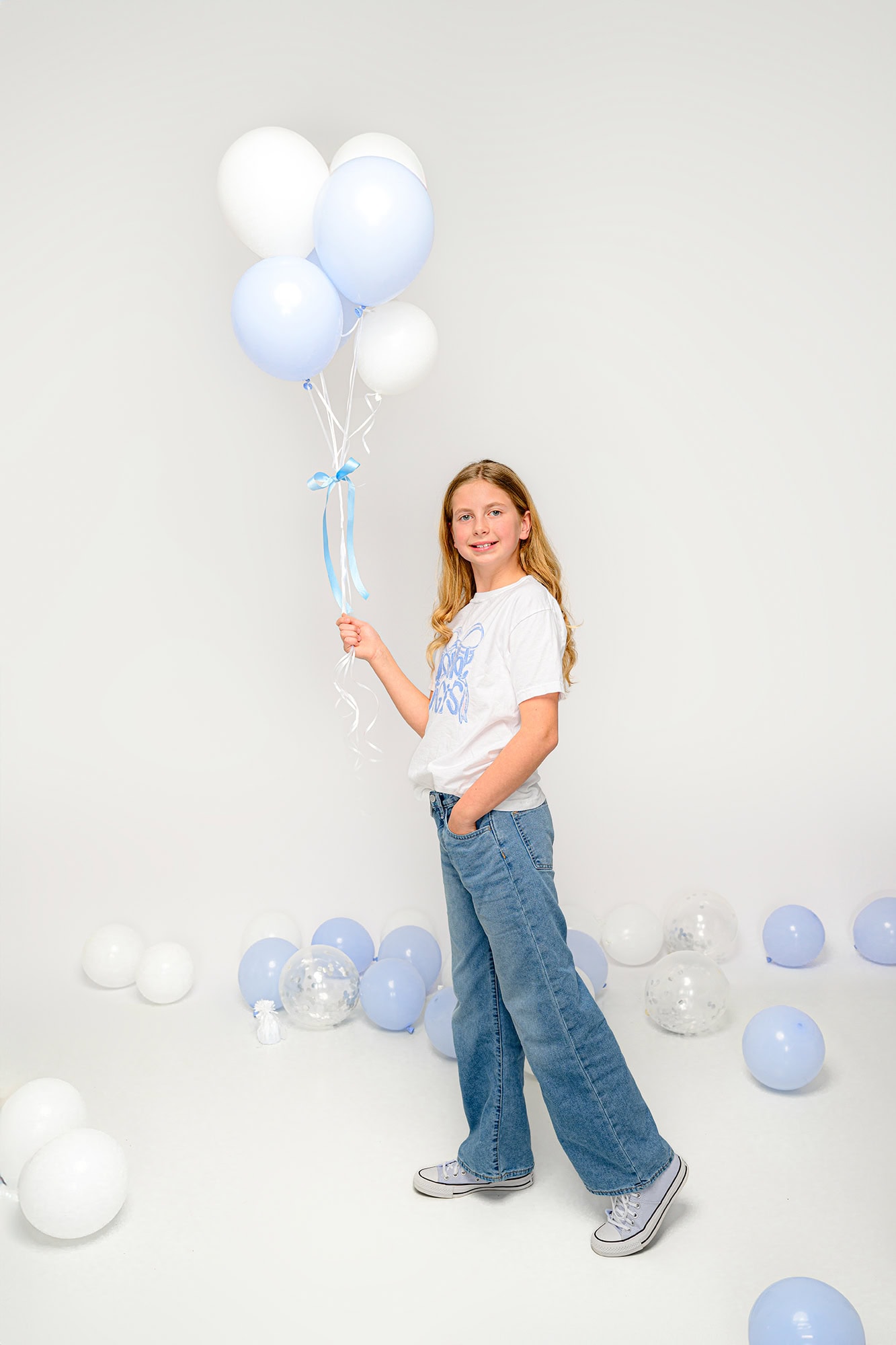 ten year old holding a bouquet of balloons to celebrate her 10th birthday
