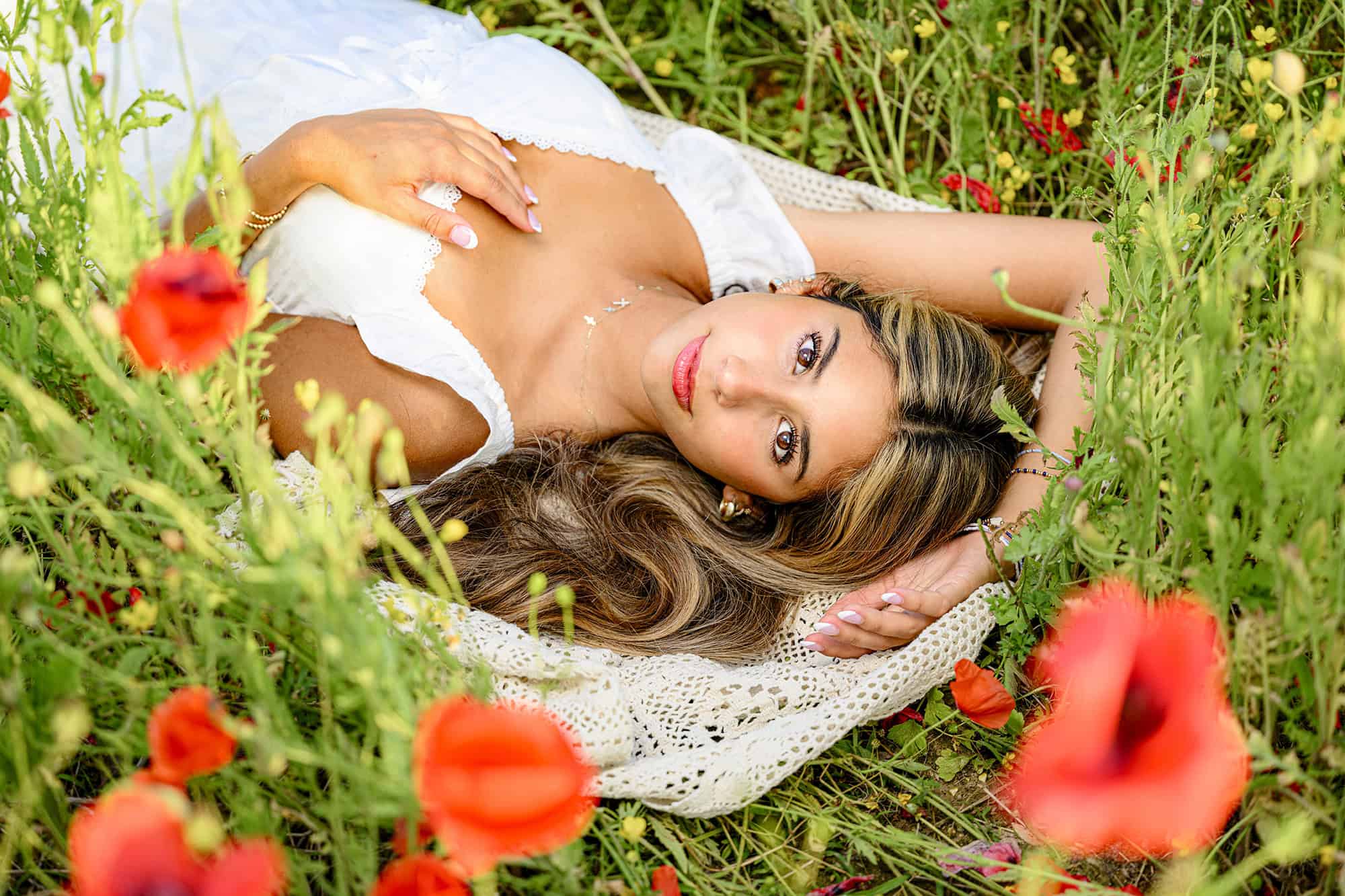 dark hair girl with brown eyes wearing a white dress lays in one of my favorite charlotte senior photo locations