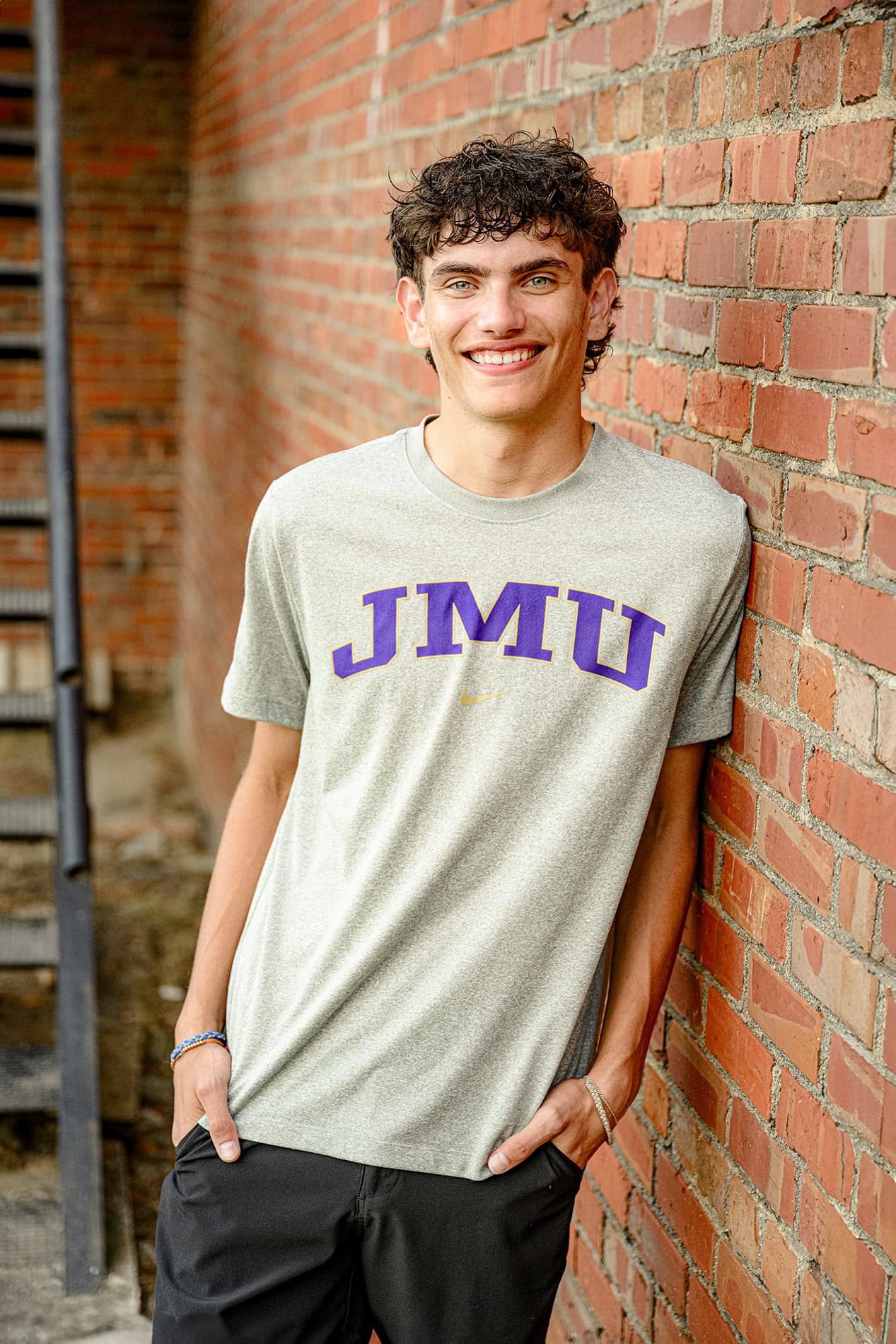 this dark hair senior boy is sporting a t shirt for her JMU college gear