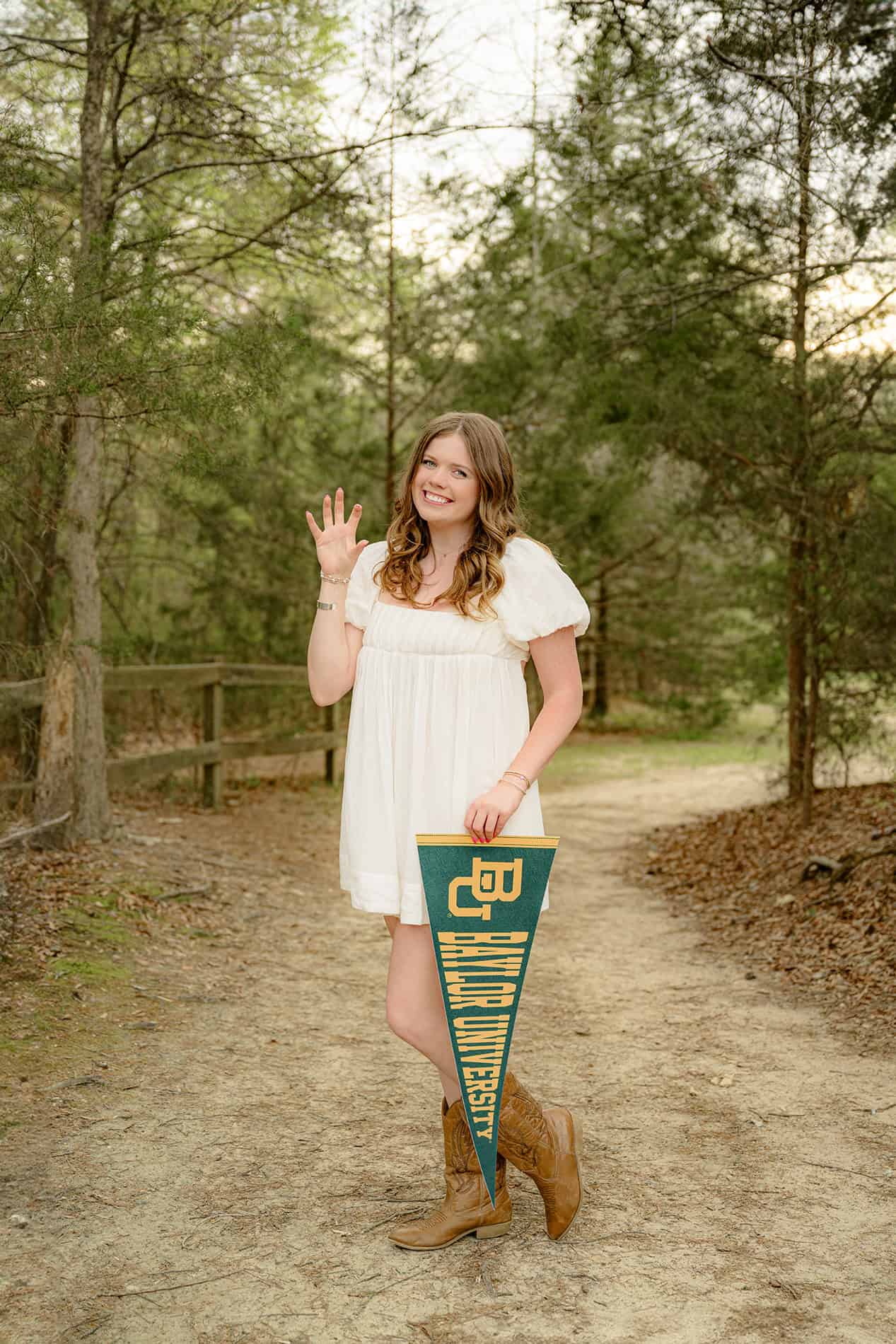 senior portrait of grad holding her baylor pennant