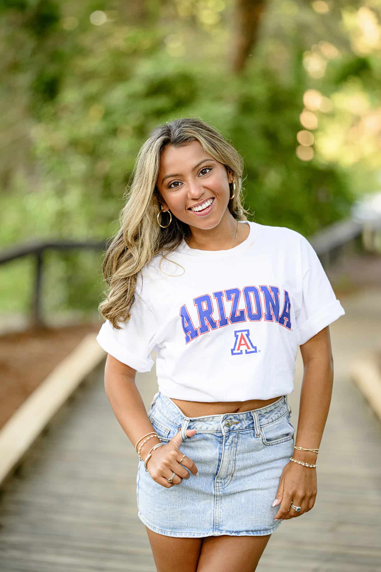 charlotte catholic grad standing on a bridge wearing a arizona shirt