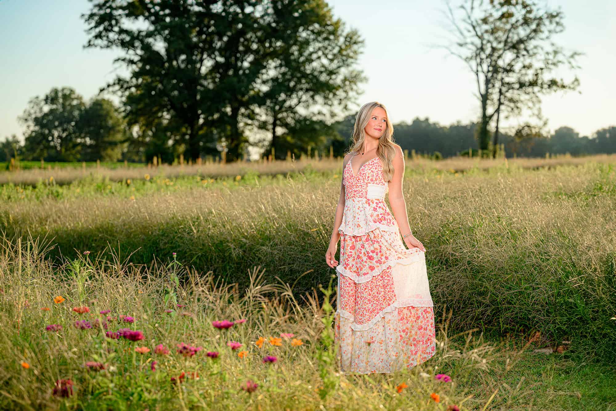 charlotte graduate stands in a wildflower field for her senior portraits to be used as her high school graduation invitiation