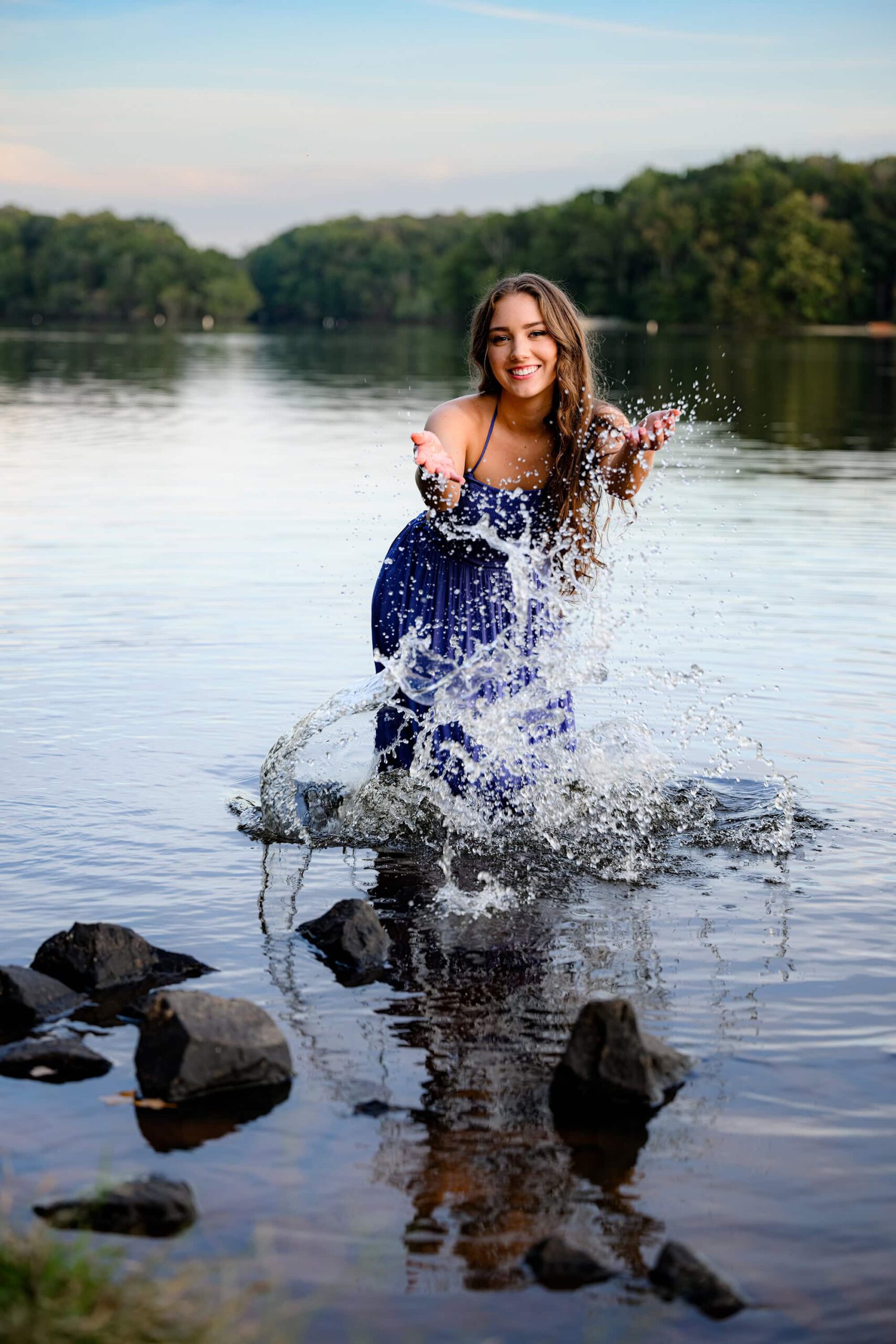 grad smiling and splashing in her senior photos