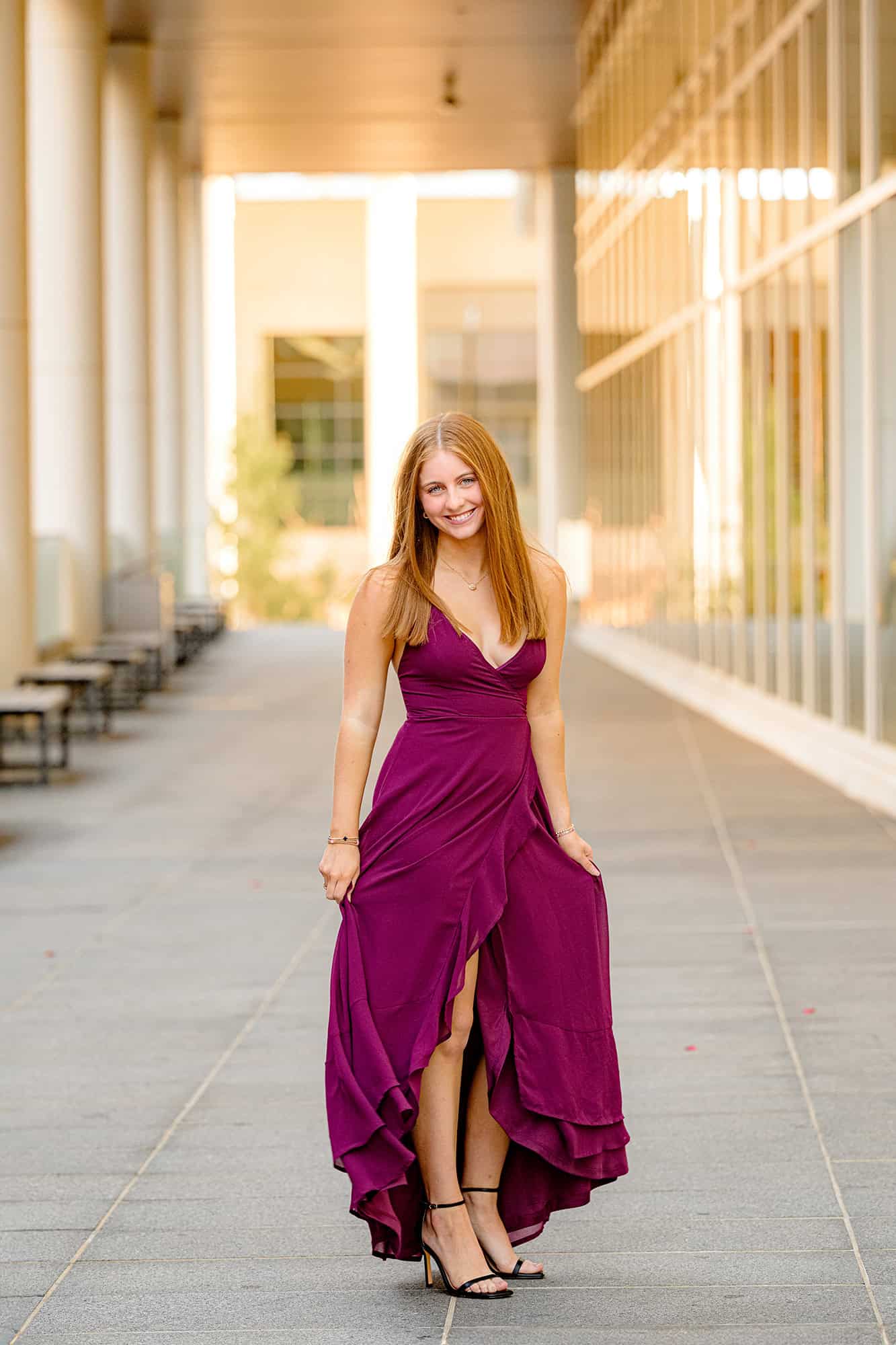 charlotte urban walkway with senior standing in a cranberry dress and black heels