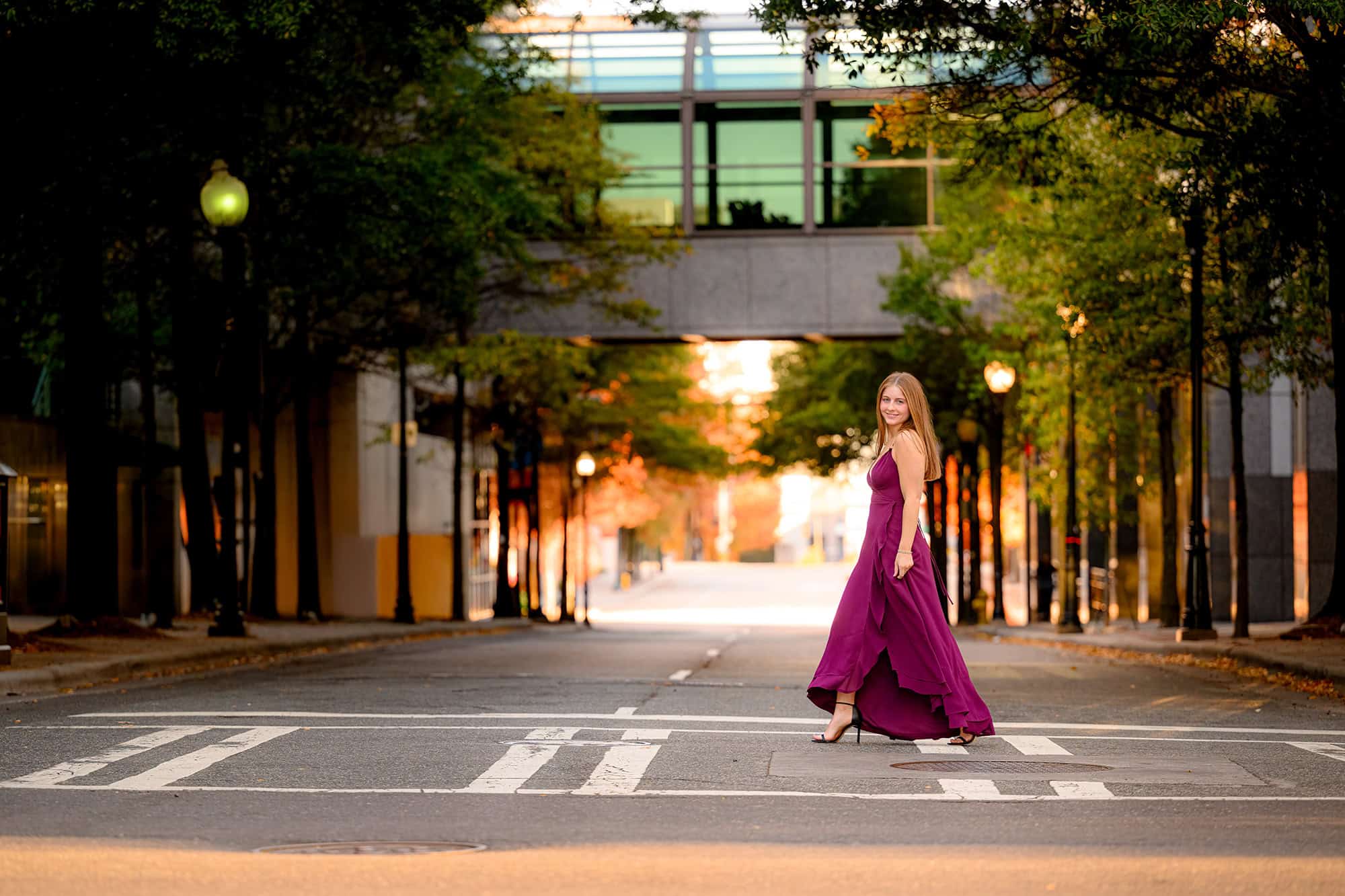 uptown charlotte street photo of senior walking in a cranberry dress