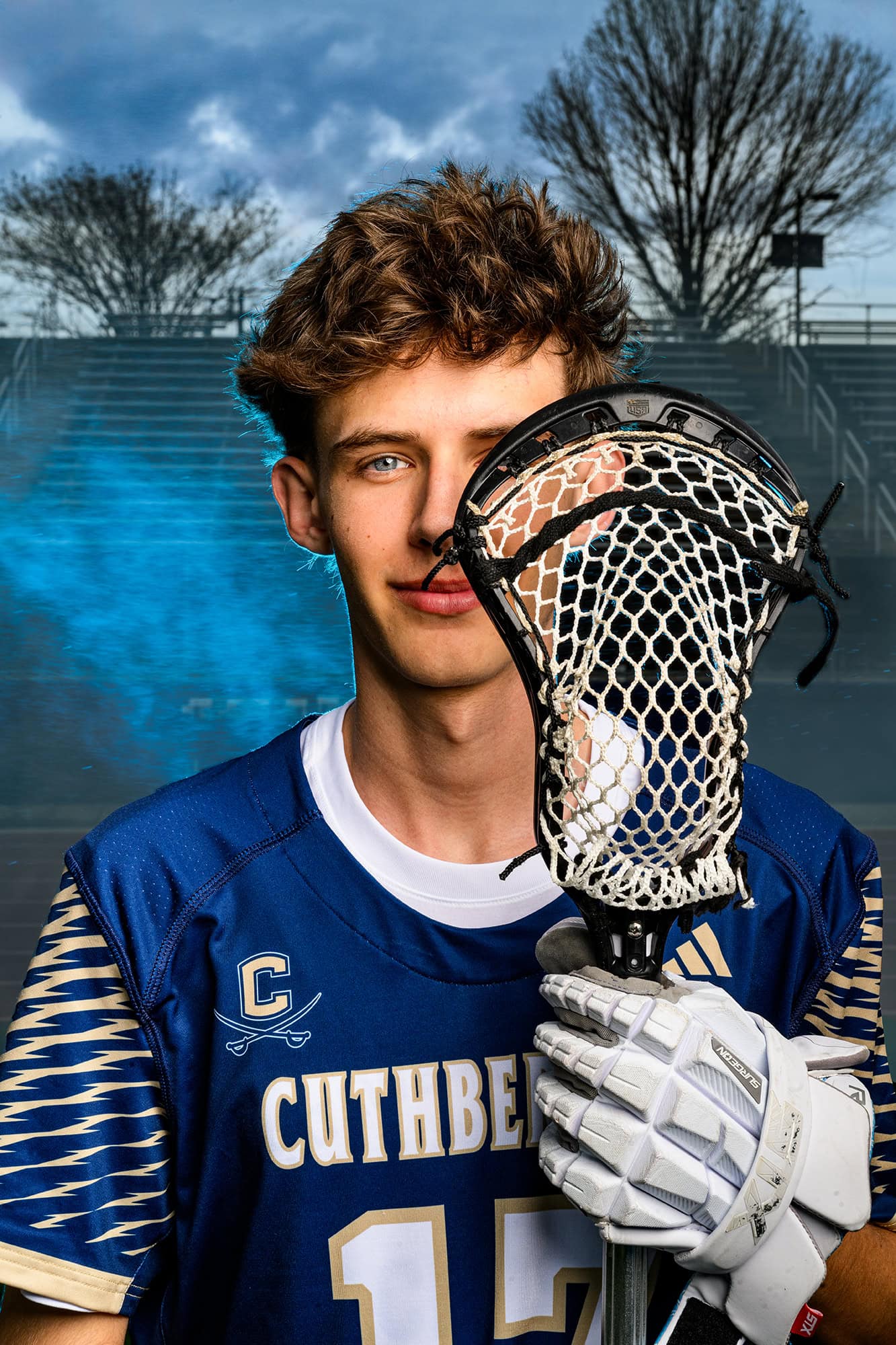 Charlotte lacrosse player holding his stick close to his face