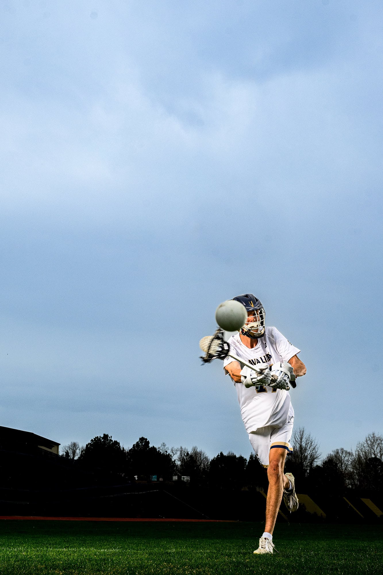 senior lacrosse player wearing his whites tossing a lacrosse ball