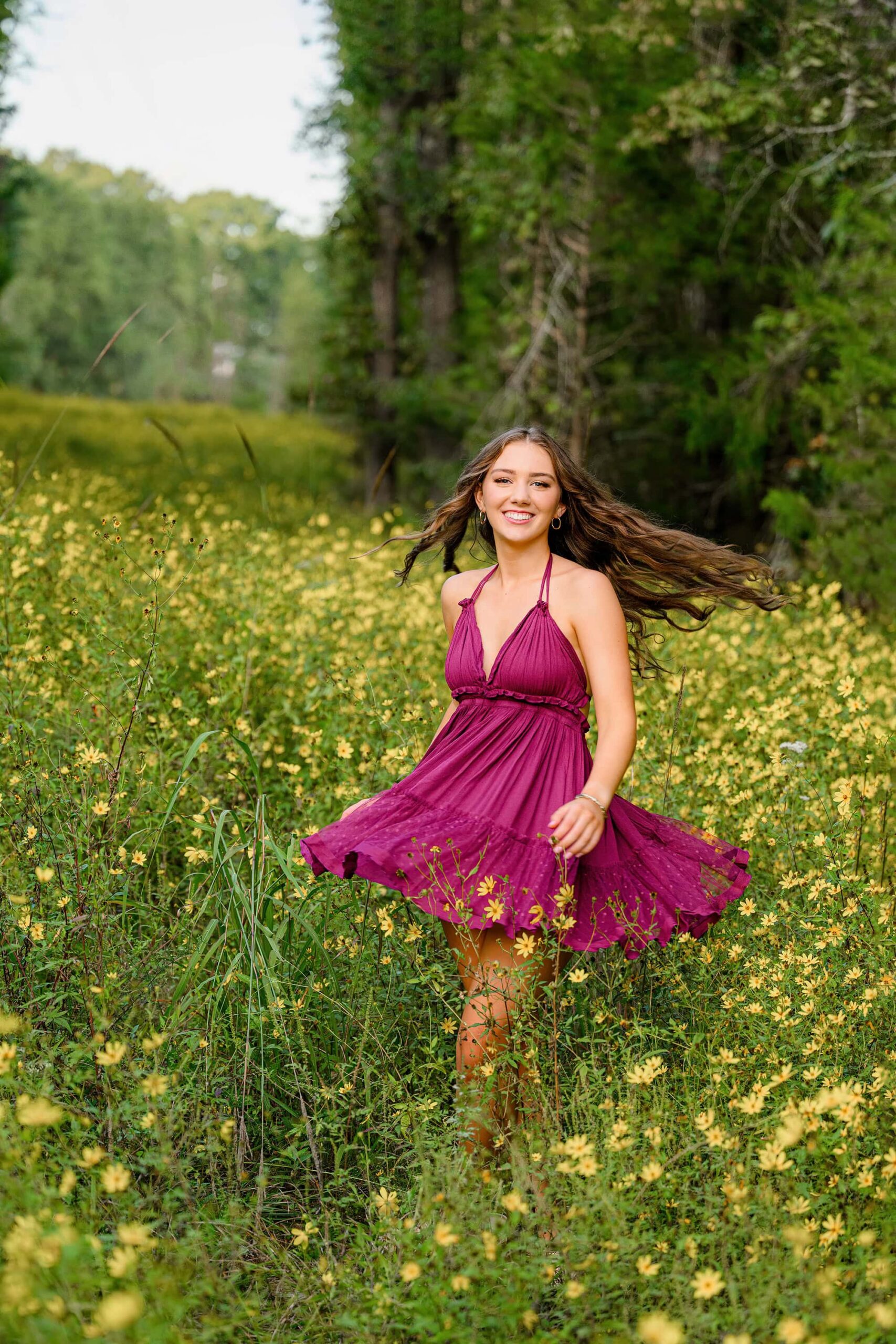 charlotte senior twirls in yellow wildflower field