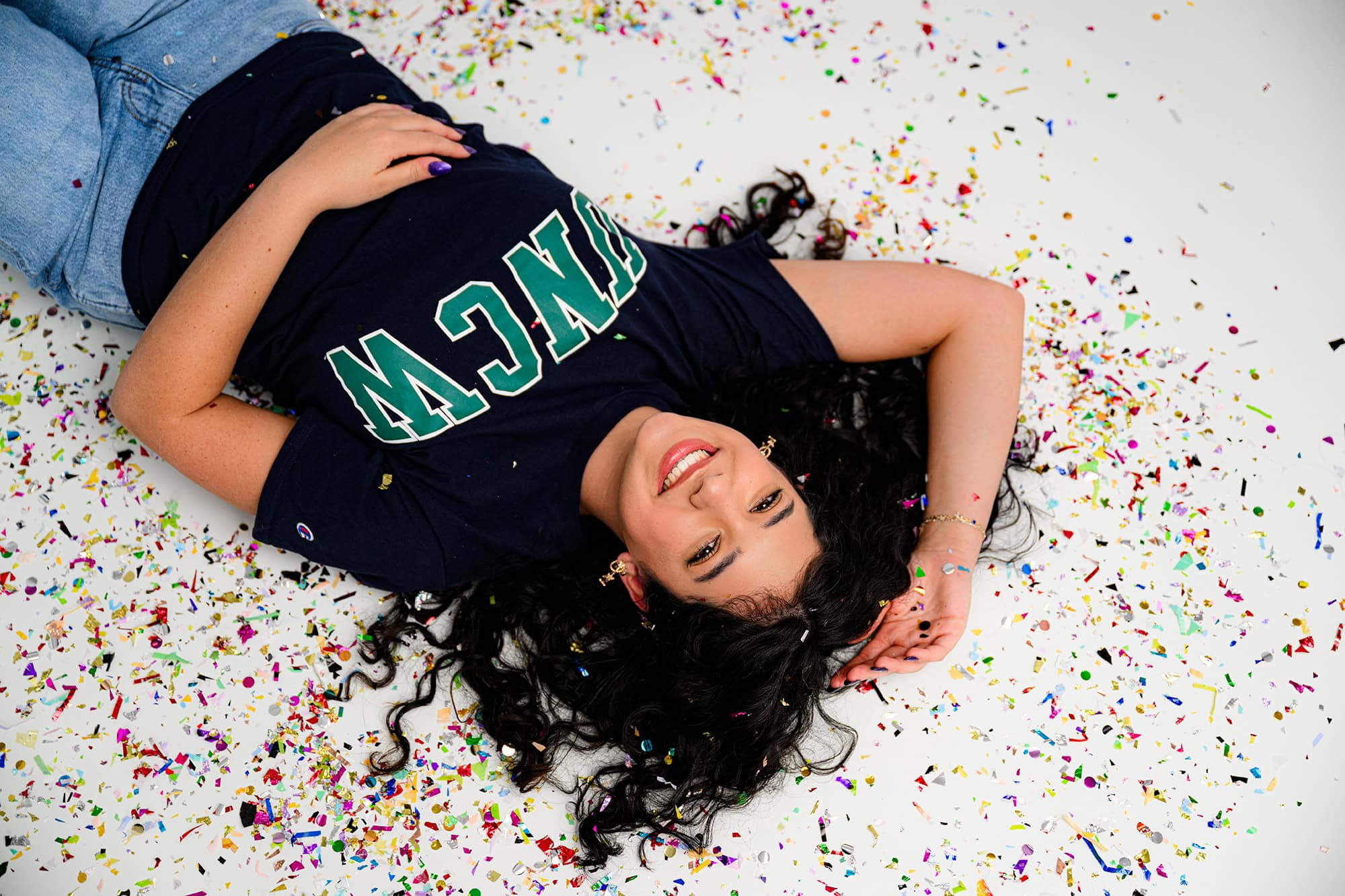 Charlotte senior laying in confetti celebrating her future college decision of UNCW