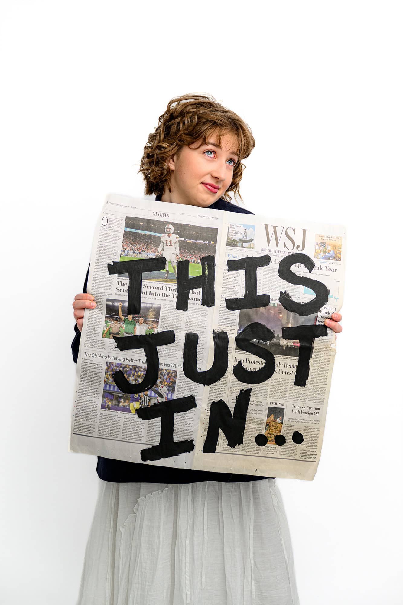 future wingate college student holding a newspaper that says "this just in" to celebrate her future college adventure