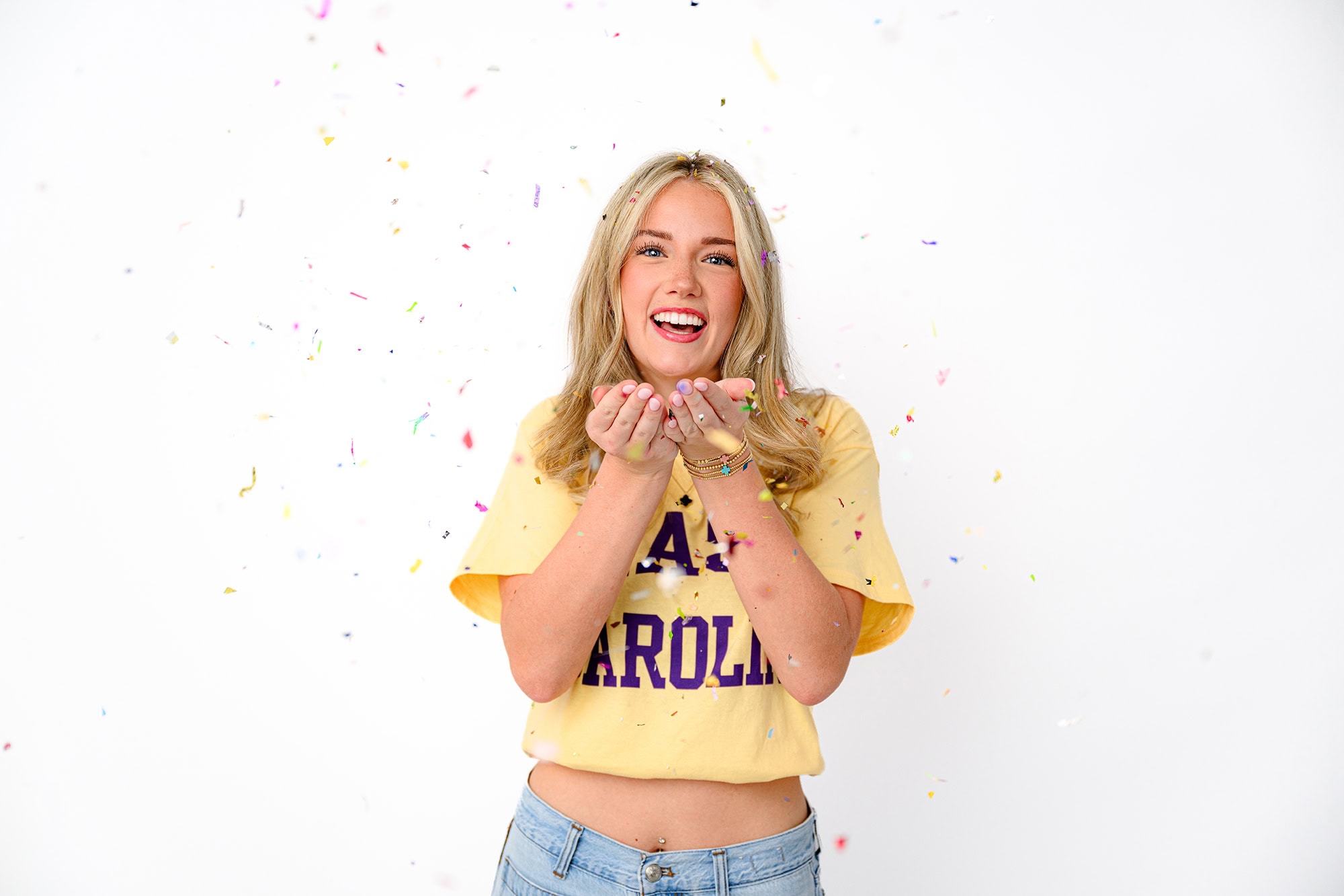 blonde charlotte senior throws confetti to celebrate her future college decision