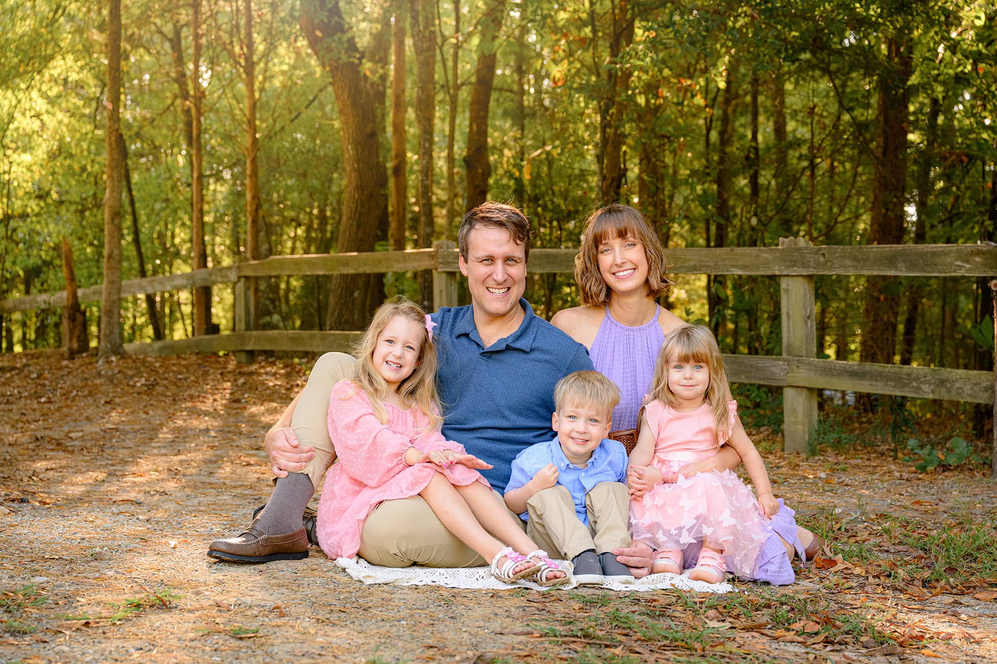 family of five wearing summer colors sitting together for a family photo