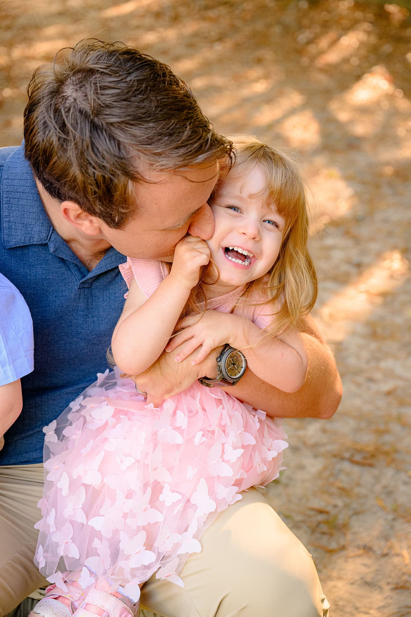 charlotte dad kisses his youngest daughter while cradling her on his lap