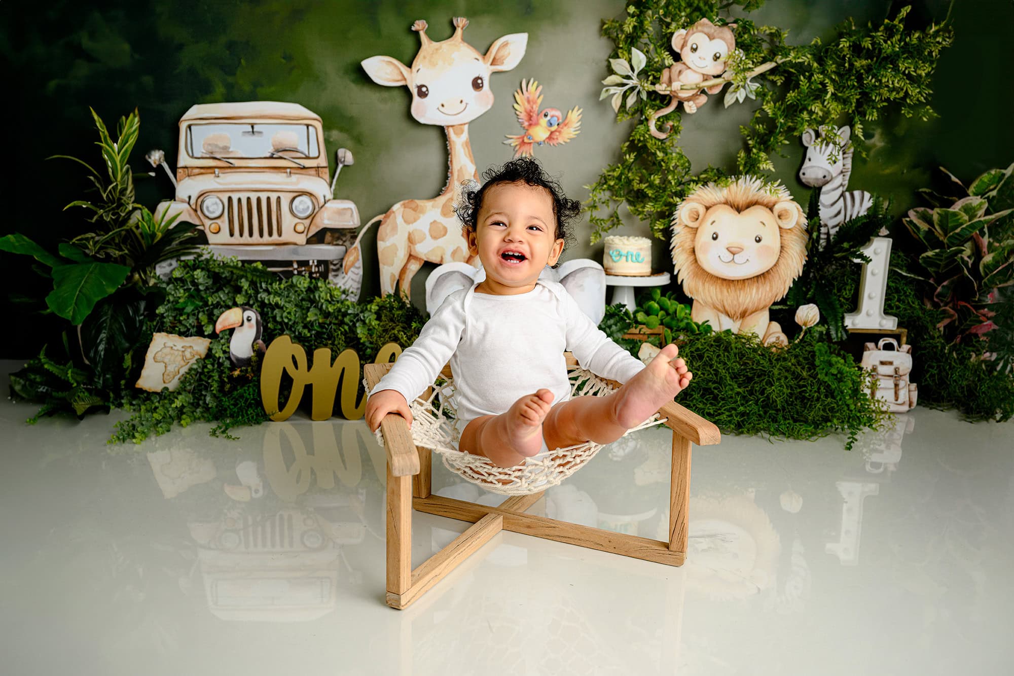 Charlotte first birthday boy sitting in a wild one themed cake smash set