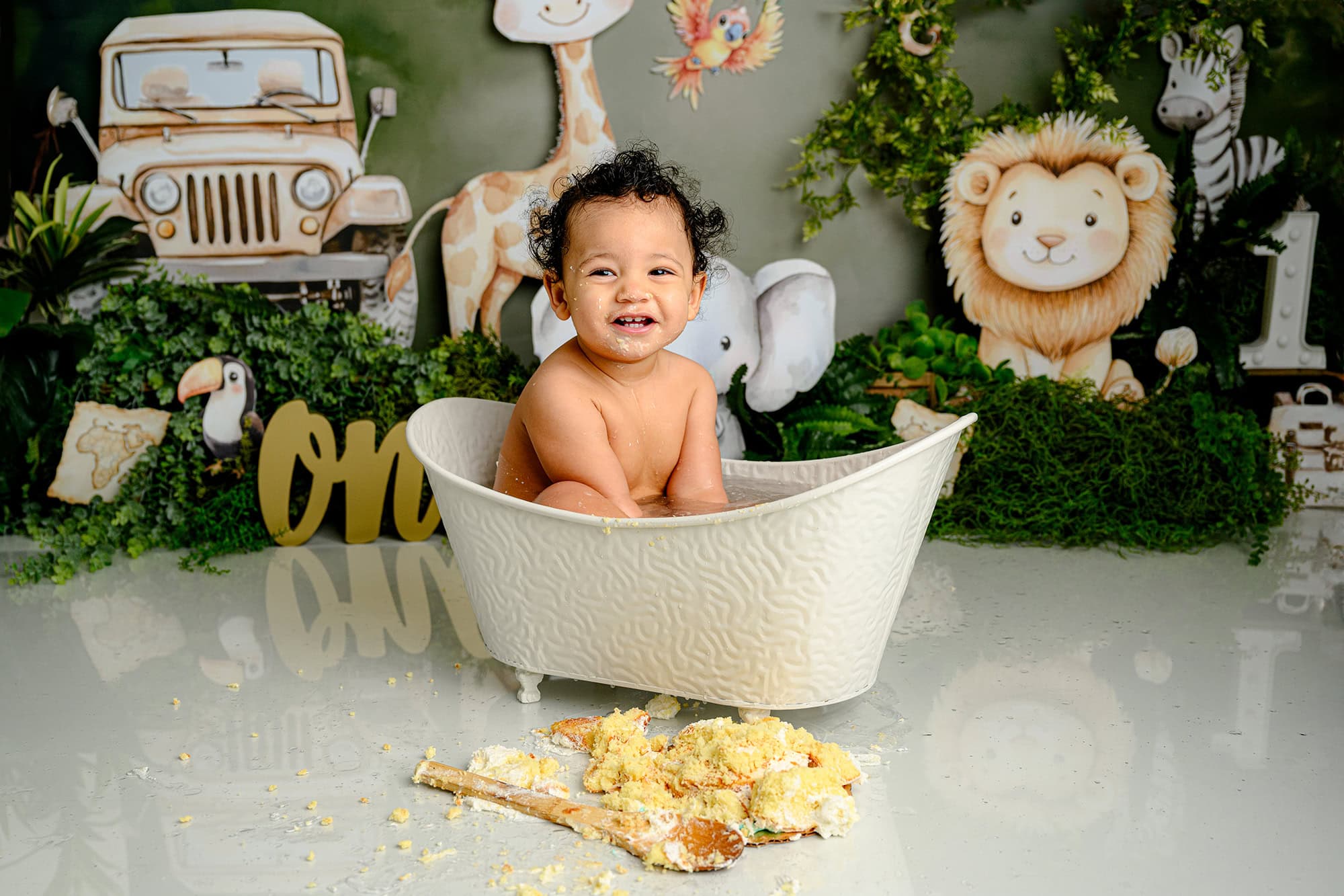 one year old charlotte boy sitting in a little tub at the end of his themed wild one cake smash session