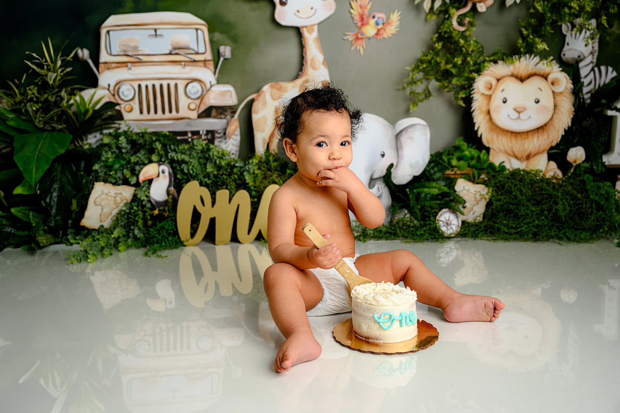 charlotte birthday boy sits in his wild one cake smash set tasting his cake for the first time