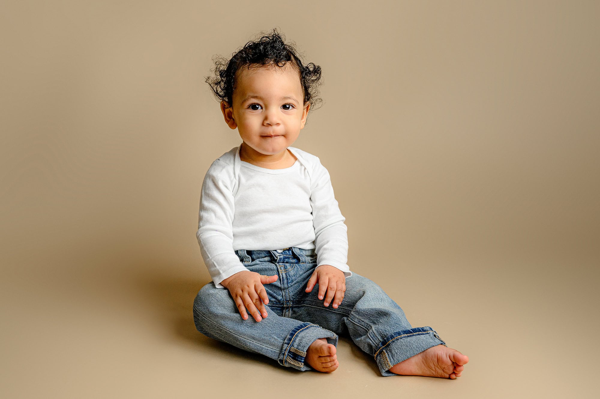 charlotte boy wearing jeans and a white top for his milestone photos in a waxhaw studio