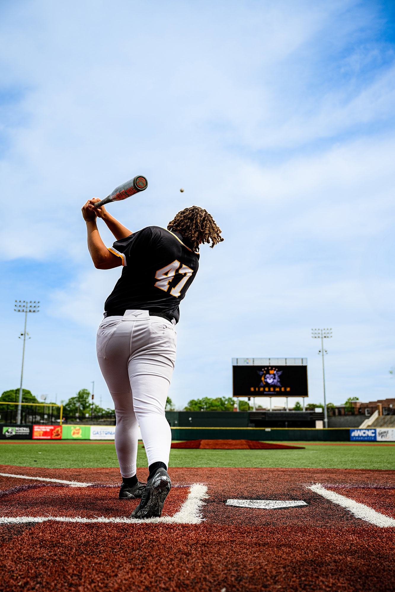 kingsmen academy baseball player hitting a ball to the outfield during senior photos