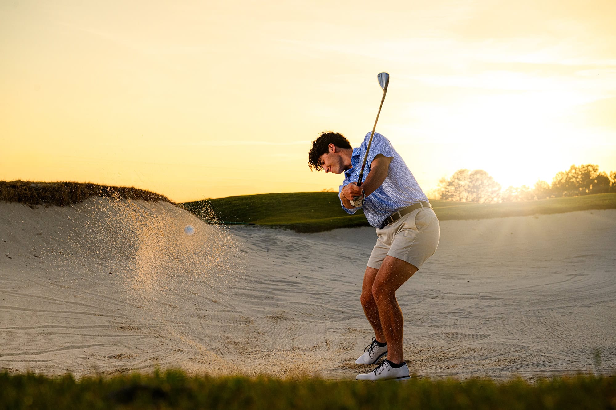 Sunset senior photo for a charlotte graduate on a golf course