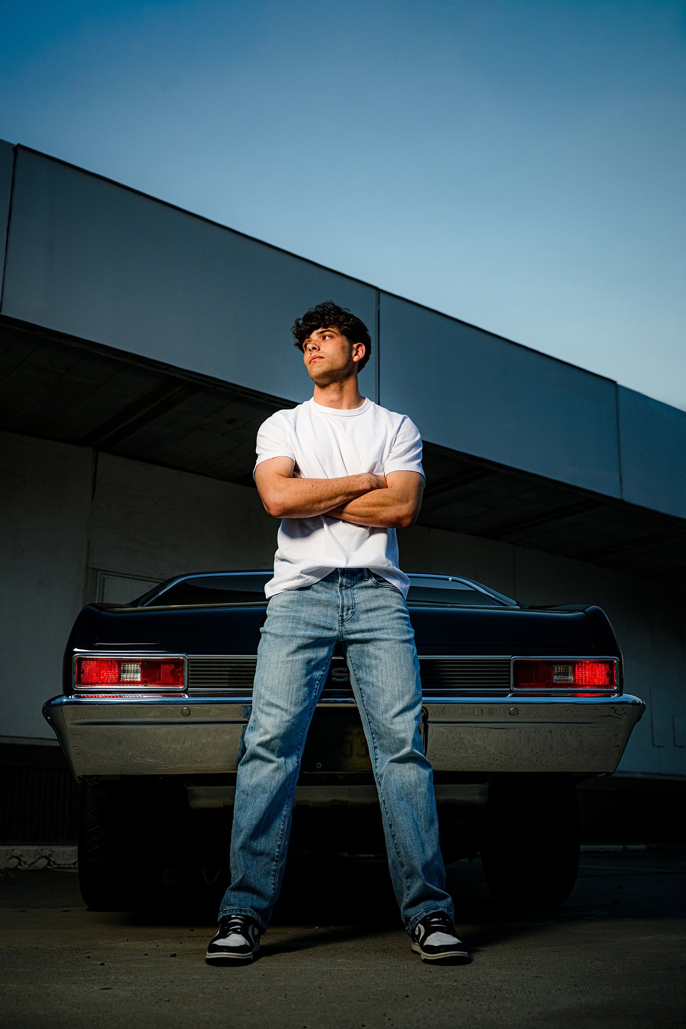 porter ridge senior leaning against a classic car wearing a white shirt and jeans for his senior photos