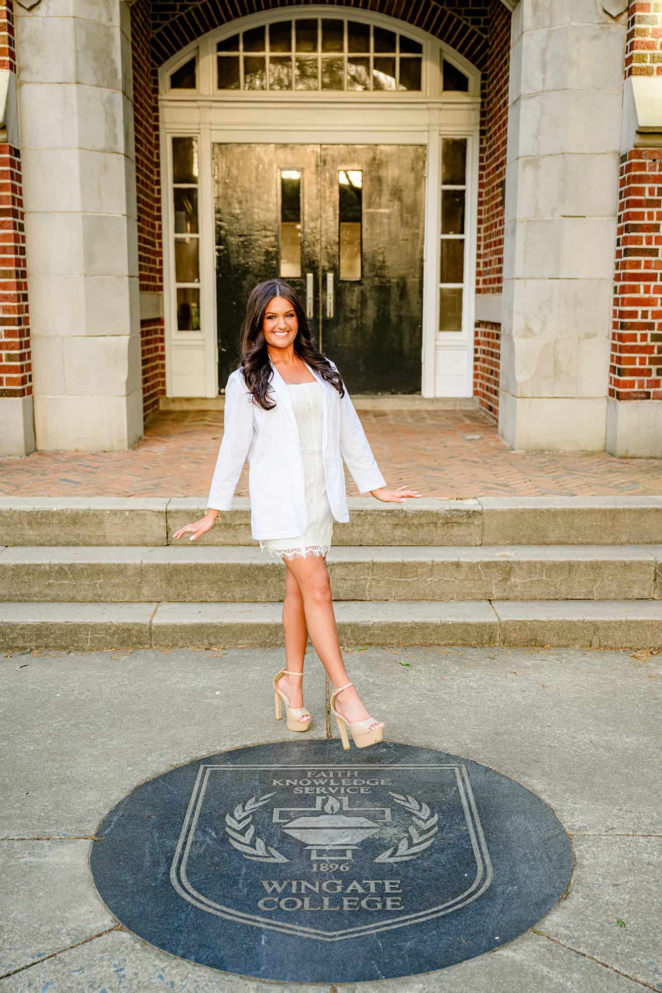 wingate university seal photo with future PharmD grad student wearing her white coat with one foot over seal