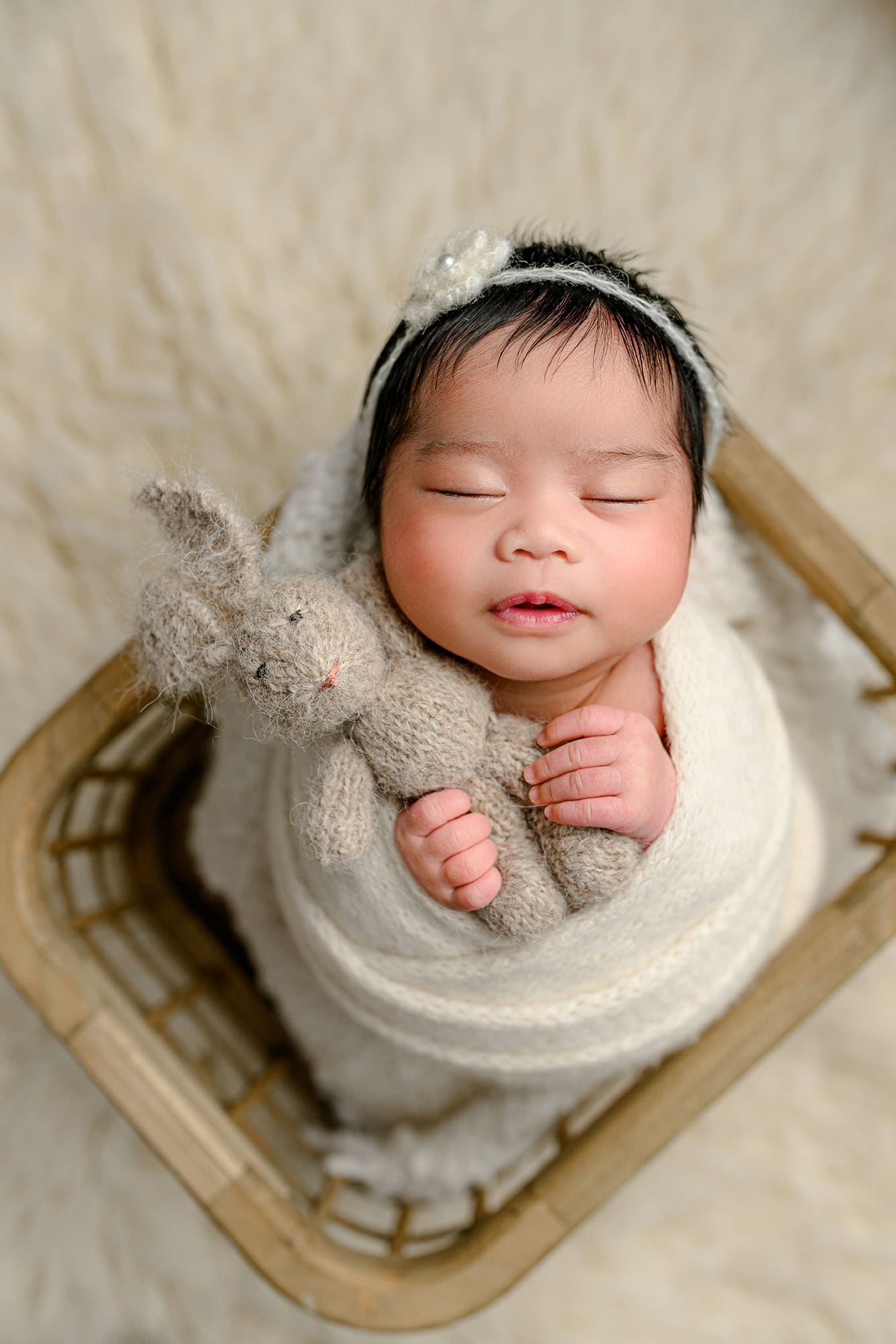 newborn baby girl holding a rabbit as a compliment to her woodland baby shower theme and nursery