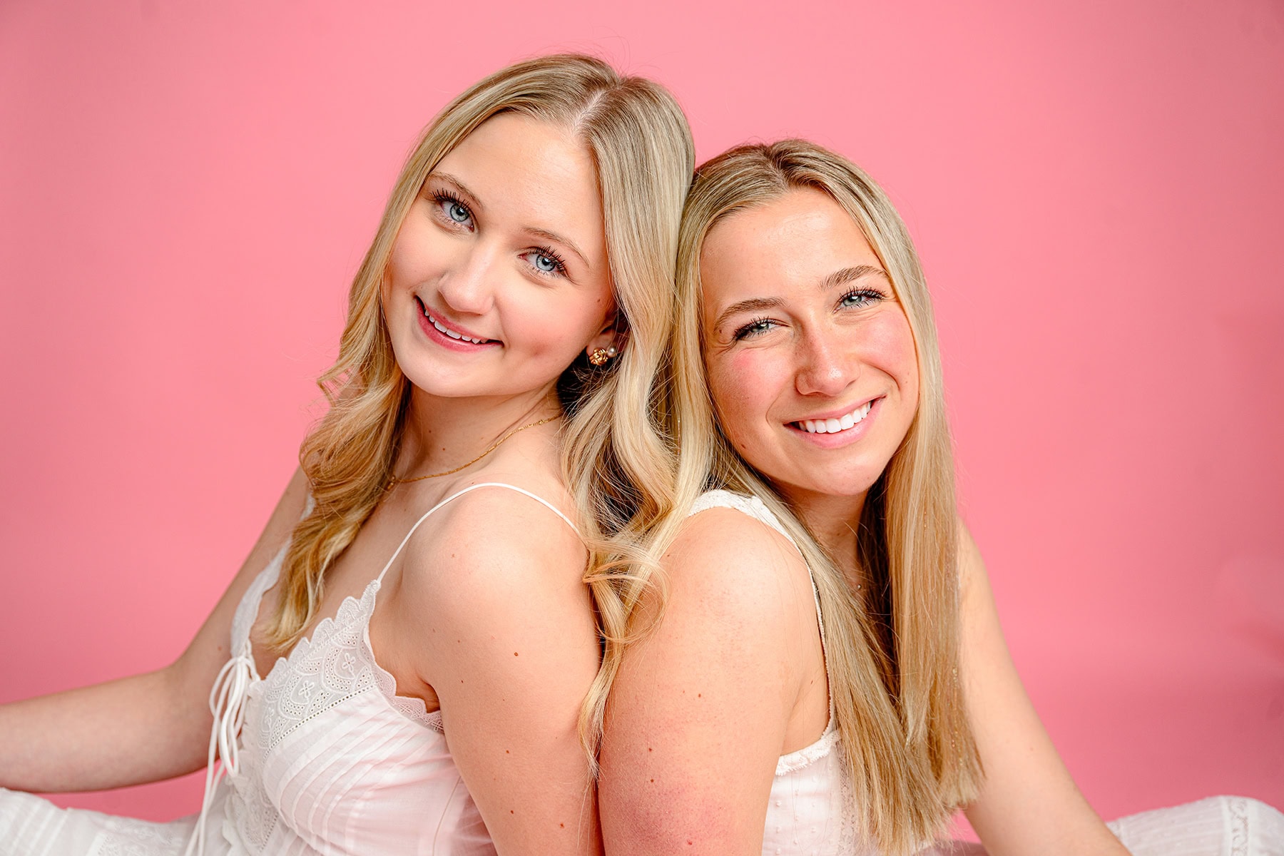 Senior bestie mini session with two charlotte catholic graduates wearing white dresses