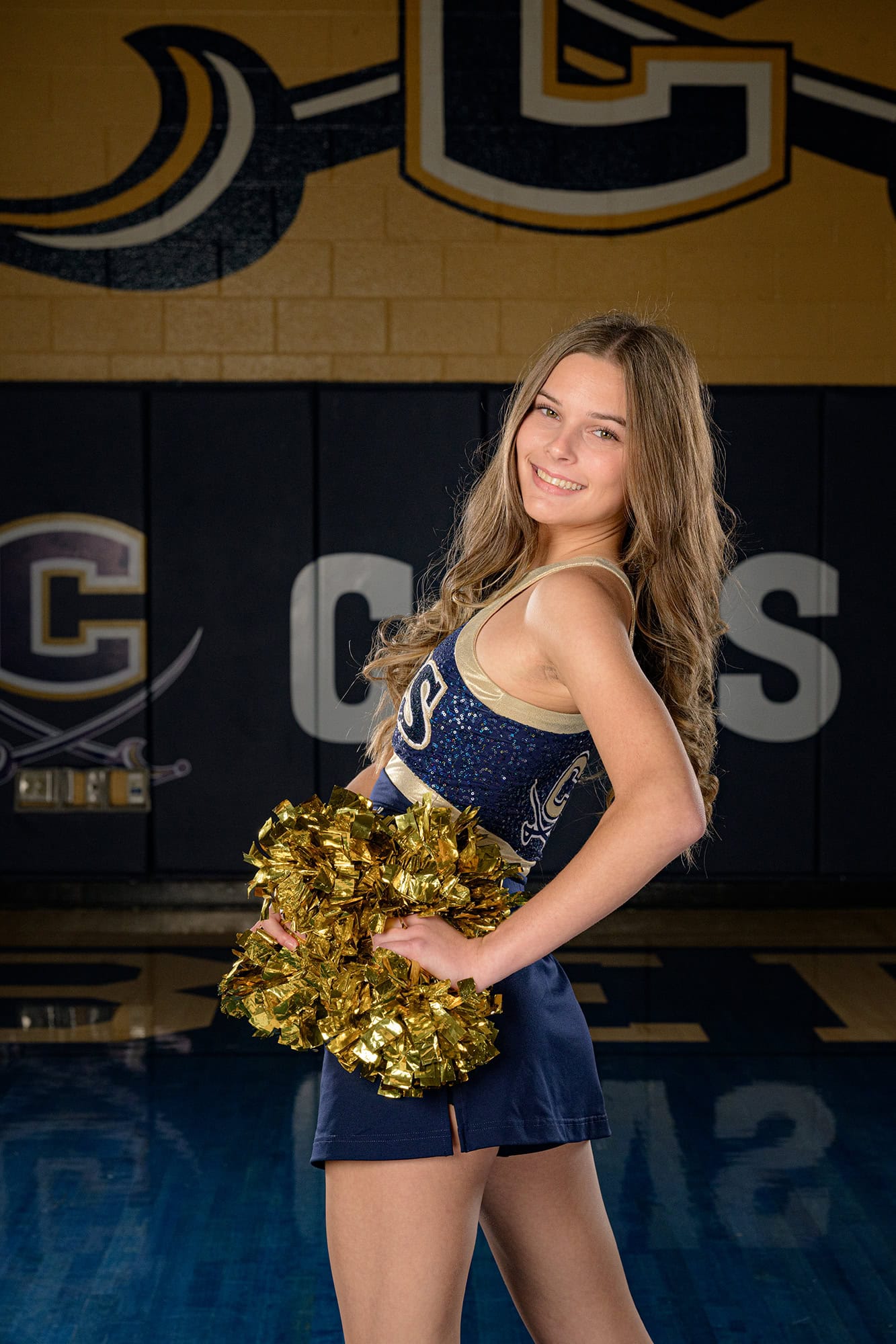 dancer looking over shoulder holding poms during media day session