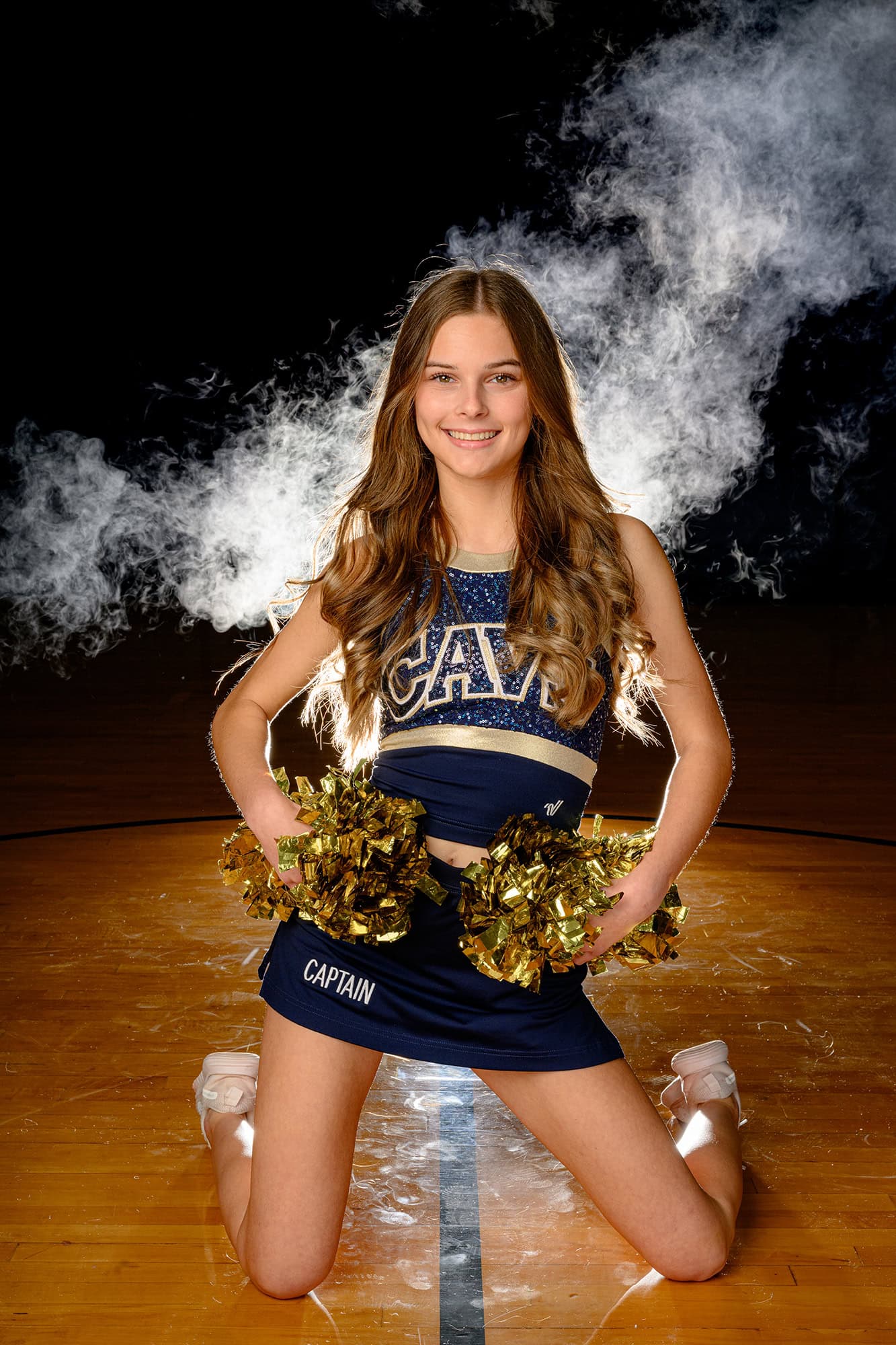 dancer sitting on floor with poms on hips