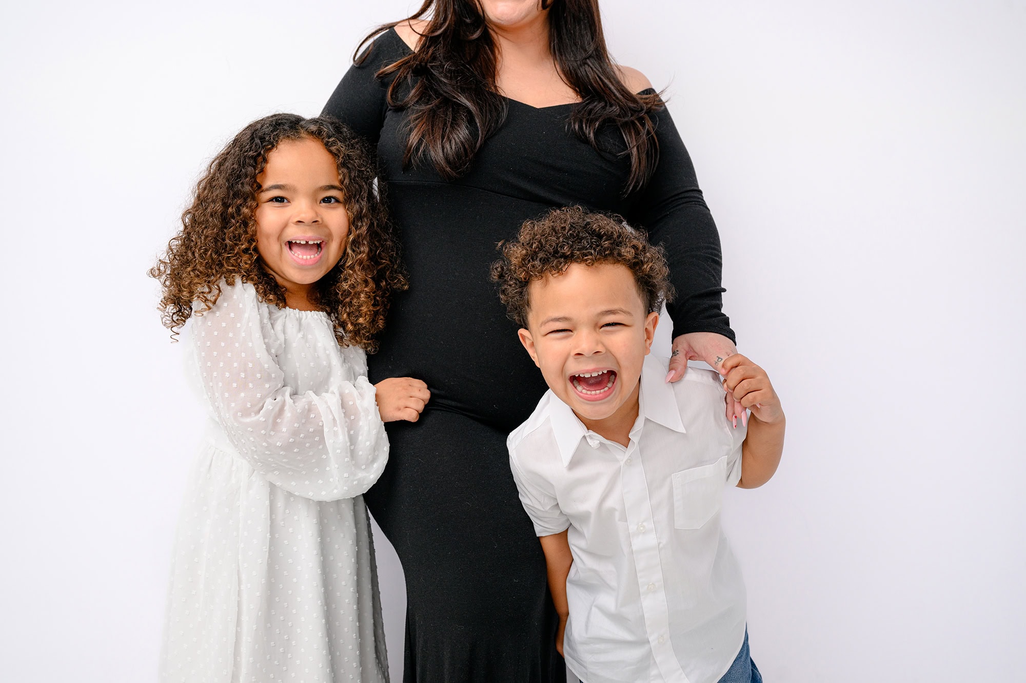 mom to be with her kids laughing during maternity photos