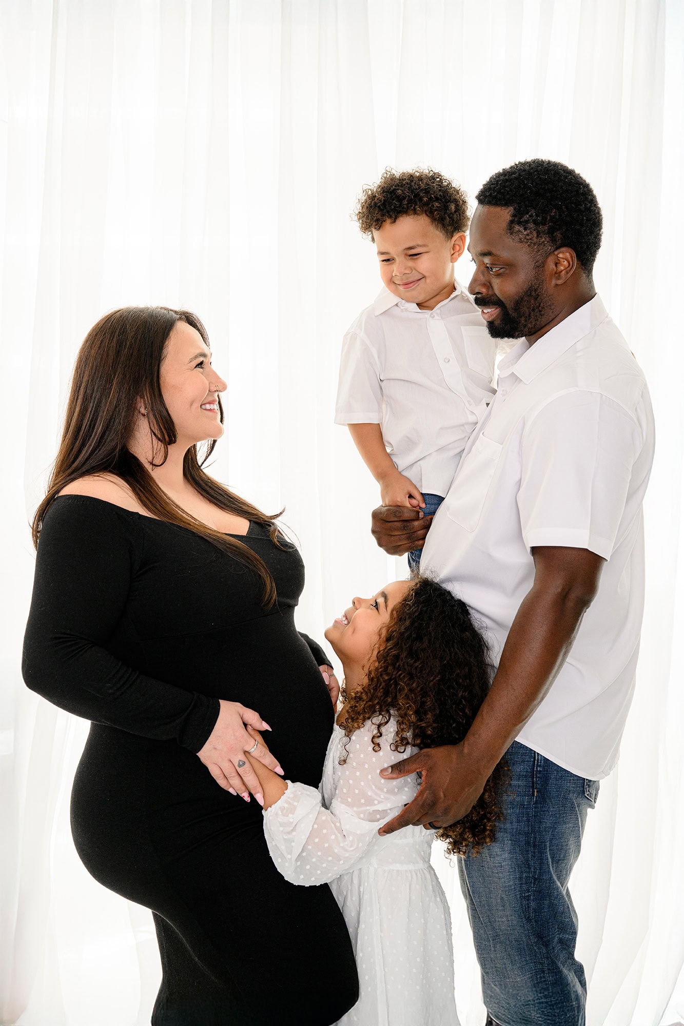 mom looking at her husband with her two kids with them for charlotte mom hospital planning