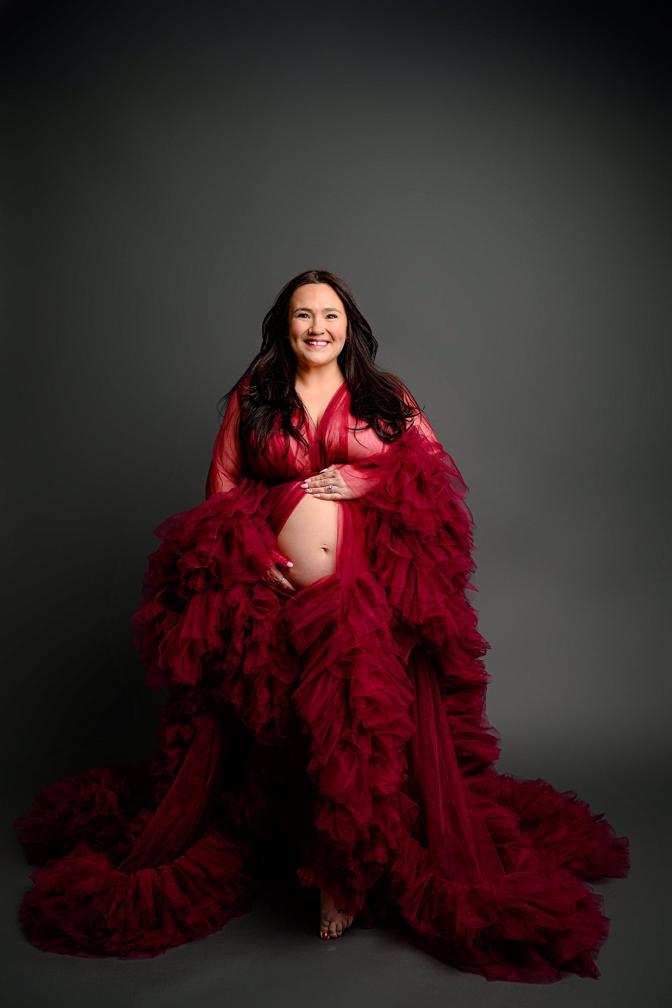 studio maternity photos all checked off for this mom to be wearing a red tulle maternity dress