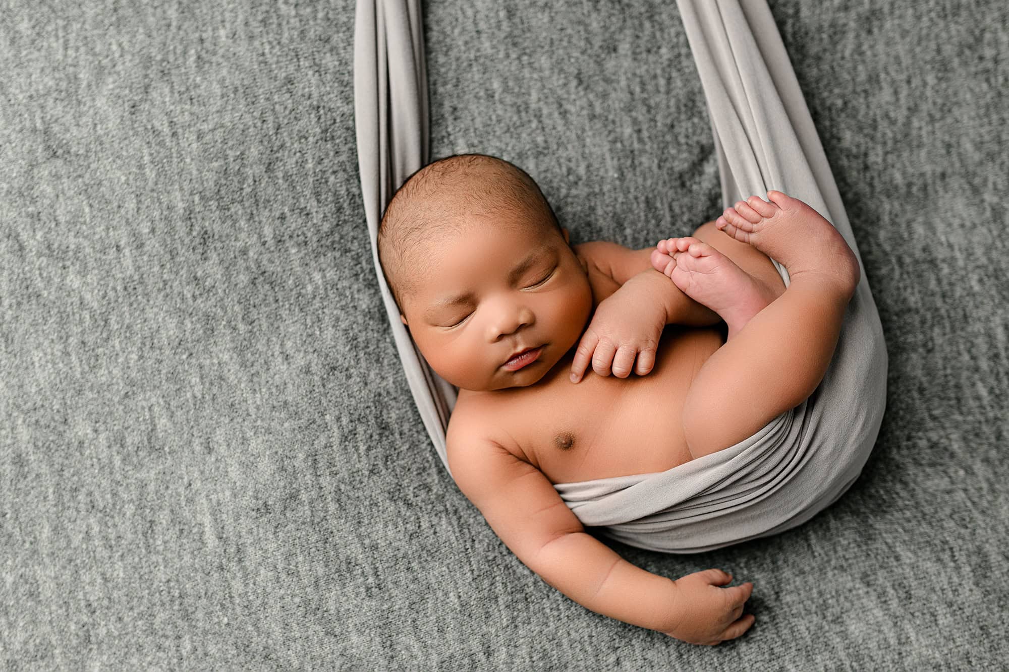 newborn baby boy in swing like pose for charlotte newborn photos