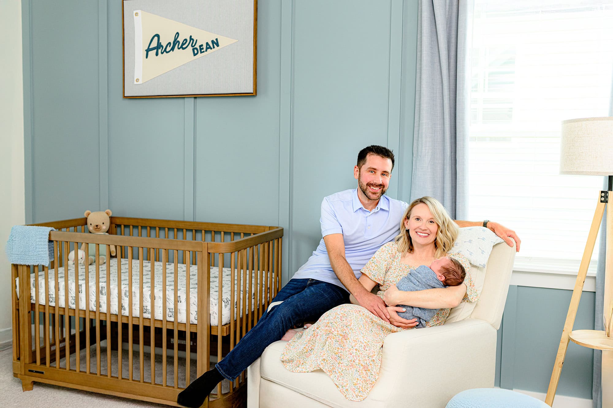 Mom holds her newborn baby boy during their charlotte lifestyle newborn session in their baby's nursery