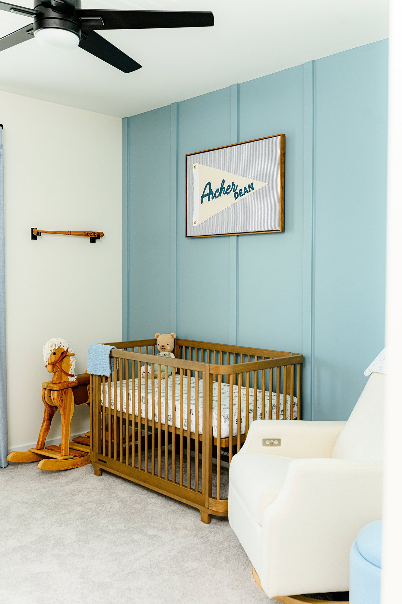 in-home newborn session baby nursery with blue wall and name plate over the crib